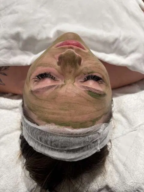 Close-up of a green clay treatment mask during a custom facial in Holland's studio